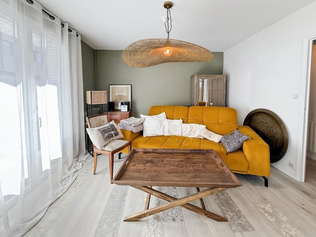 a living room with a yellow couch and a table at Appartement 95m2, Cœur d'Aurillac, Jusqu'à 5 pers in Aurillac