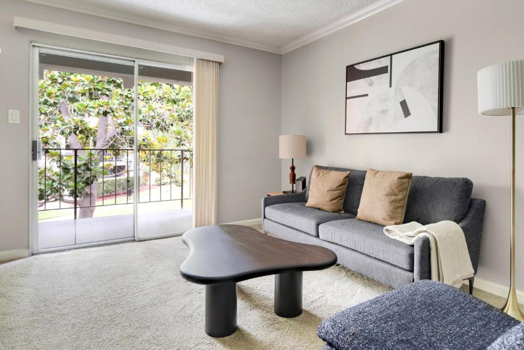 a living room with a couch and a table at Blueground Campbell pool nr Campbell Park SFO-1998 in Campbell