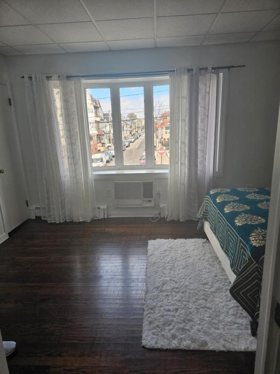 a bedroom with a bed and a large window at Cozy Getaway in Kearny