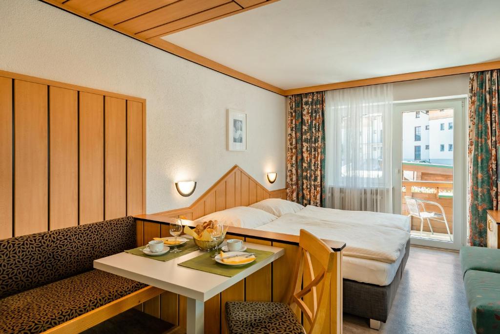 a hotel room with a bed and a table at Appartement 14 - Haus Voglreiter in Kaprun