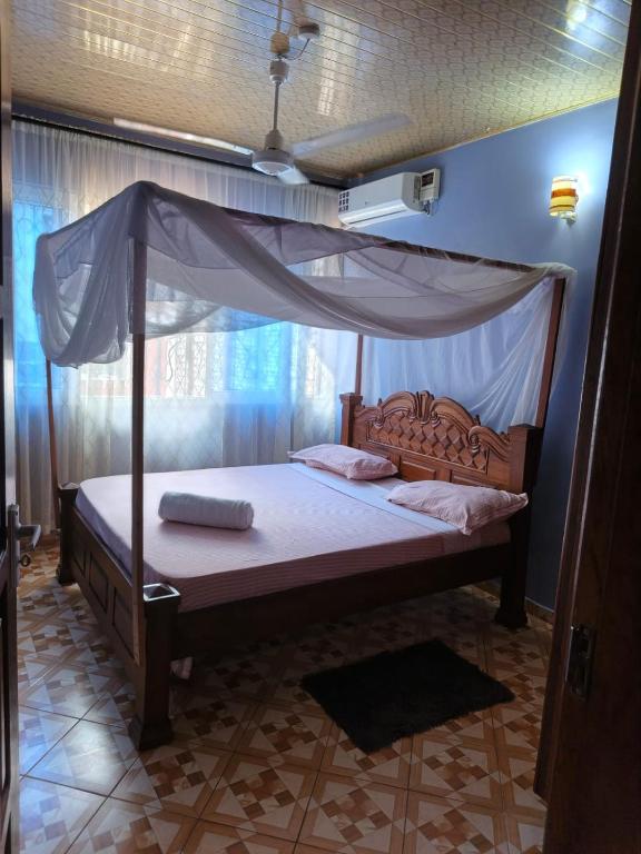 a bed with a canopy in a room at BnB in Mombasa