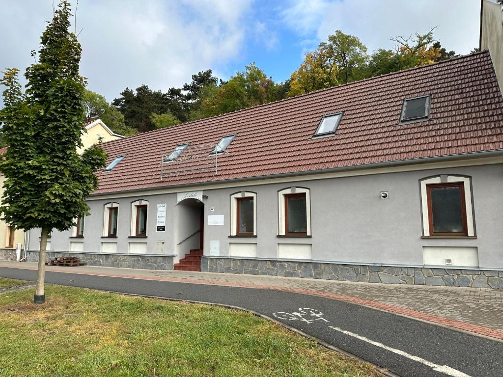 een wit gebouw met een rood dak op een straat bij Penzion Laskala in Tišnov