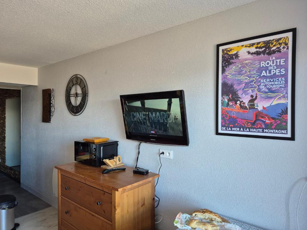 a living room with a tv on a wall at Studio LE CORBIER in Villarembert