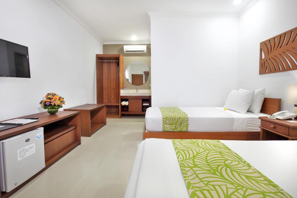 Postel nebo postele na pokoji v ubytování Dewi Sri Hotel