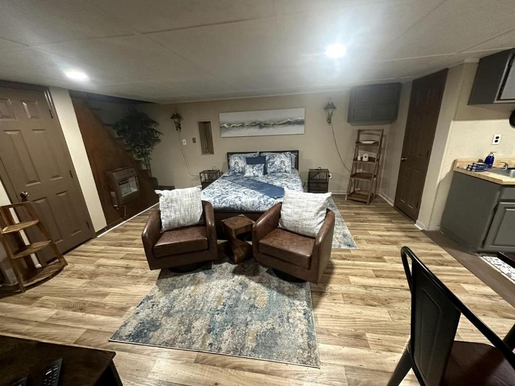 ein Wohnzimmer mit einem Bett und Stühlen in der Unterkunft Cozy Cabin for Two by the Lake for a Peaceful Escape in Opelika, Alabama in Opelika