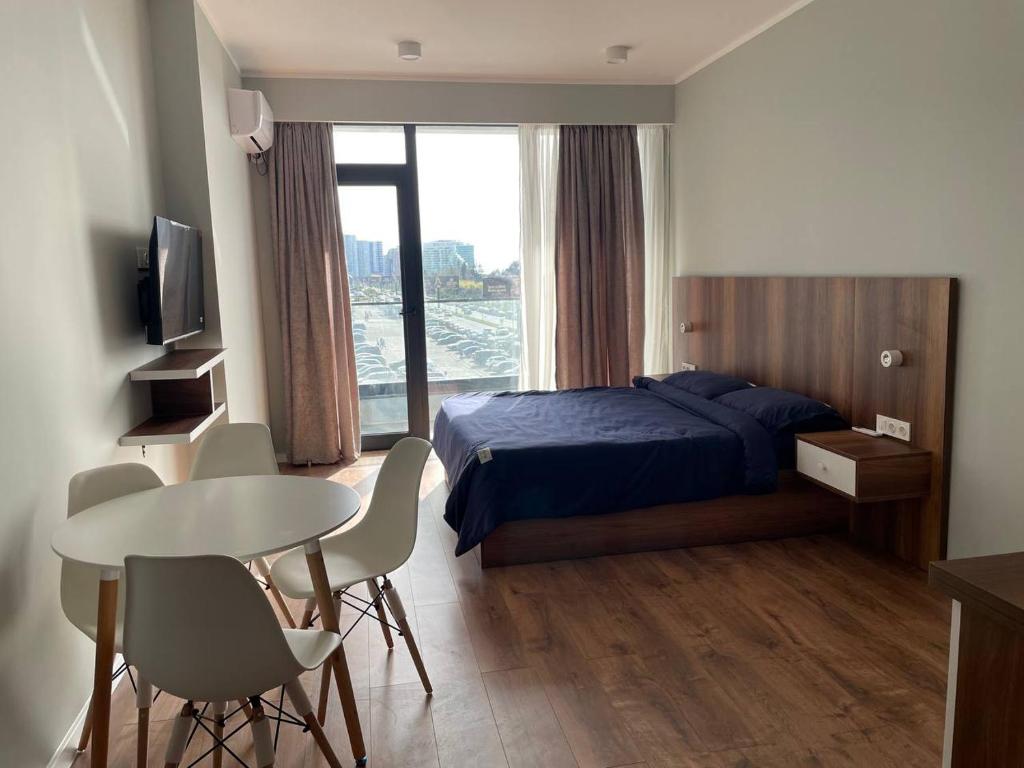 a hotel room with a bed and a table and chairs at La Vita Batumi in Batumi
