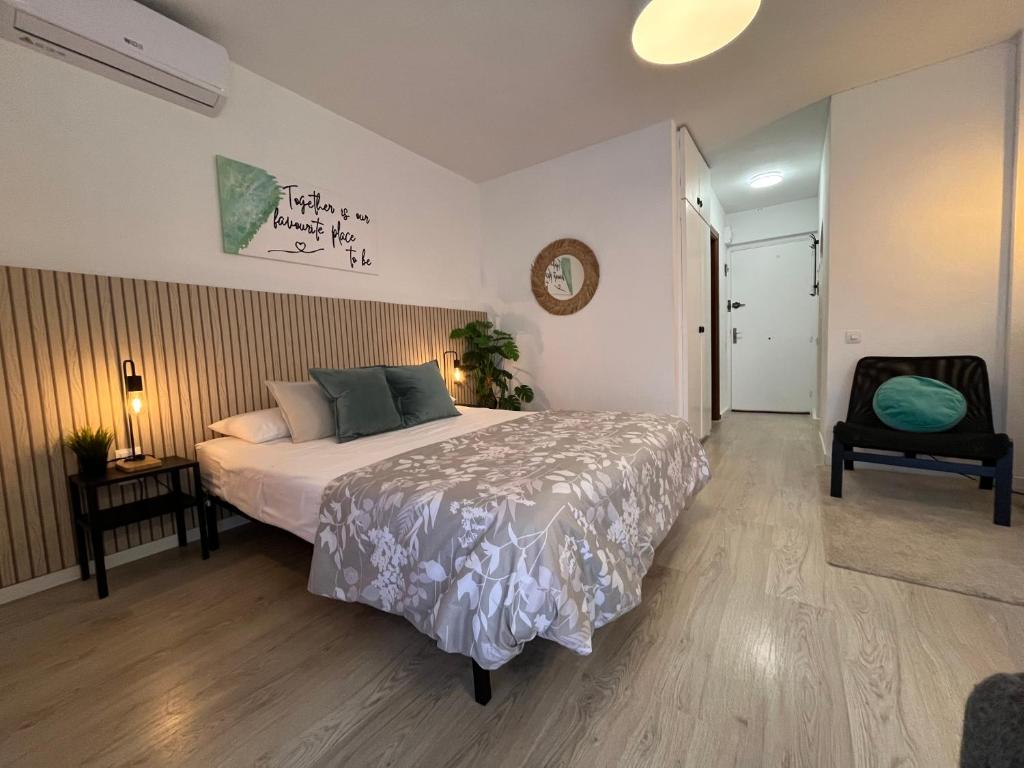 1 dormitorio con 1 cama, 1 silla y 1 reloj en Apartment Coastal Feeling in Hercules Sea views, en Benalmádena