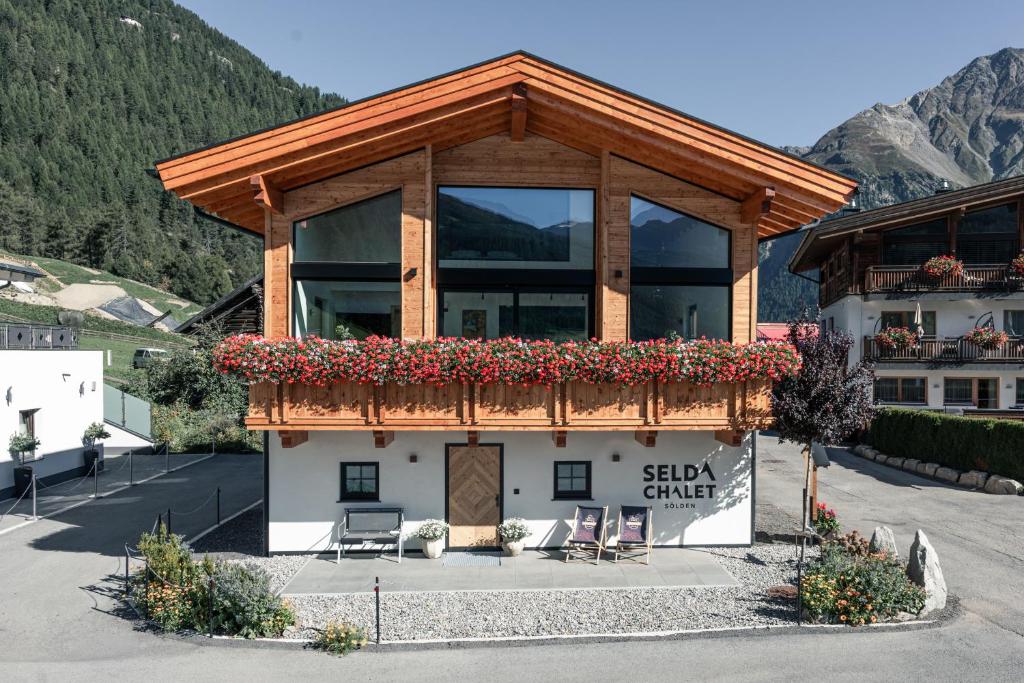 a building with a balcony with flowers on it at Selda Chalet in Sölden