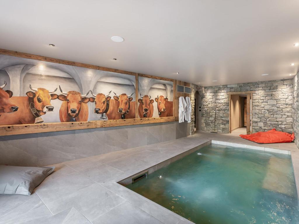 a room with a swimming pool with cows on the wall at Chalet d'exception avec piscine, spa et hammam - 14 pers., Saint Martin de Belleville - FR-1-570-54 in Saint-Martin-de-Belleville