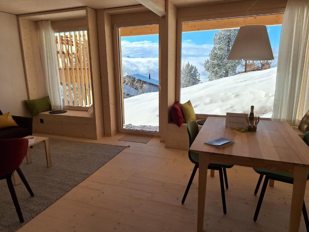 a living room with a table and a large window at StrohGlück Rigi - traumhafte nachhaltige Ferienwohnungen mit toller Aussicht in Rigi Kaltbad
