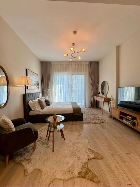 a bedroom with a bed and a couch and a tv at Chez Teo in Abu Dhabi
