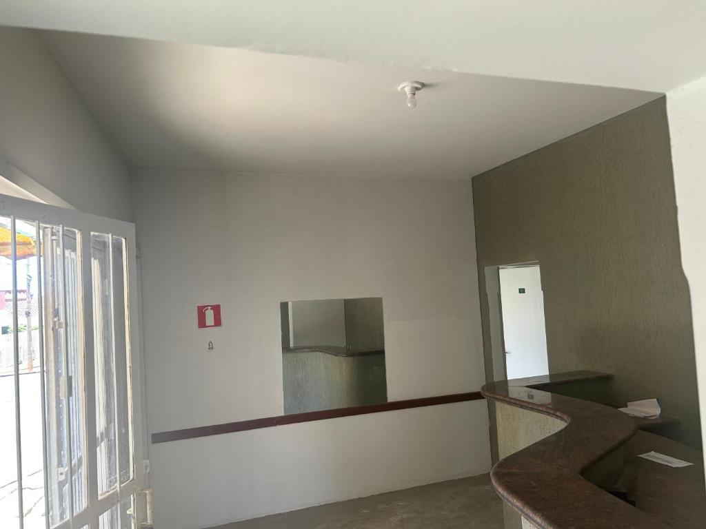 an empty room with a mirror on the wall at Suíte 05 no centro da cidade in Uberaba