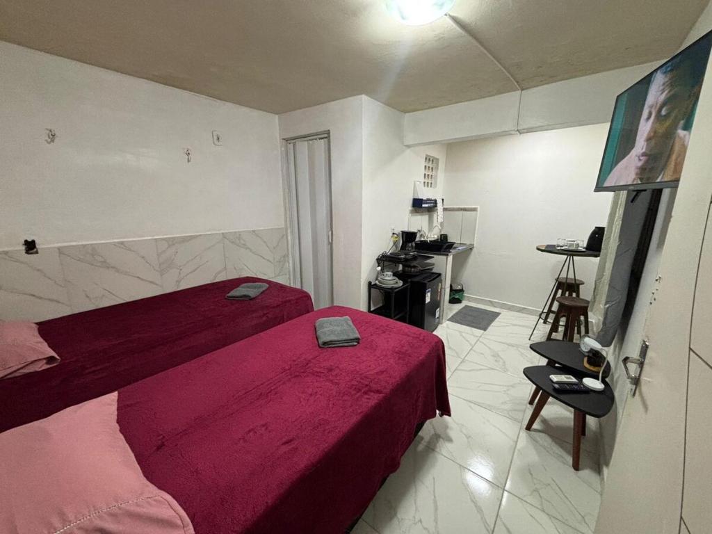 a bedroom with a bed with a red blanket at Suite COP30 Cozinha e Ar Condicionado Express Centro in Belém