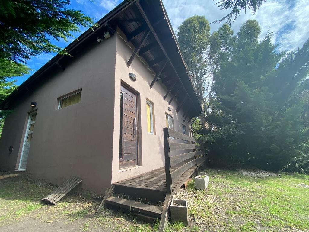 a small house with a porch and a door at Cabañas Cruz del Sur in Miramar