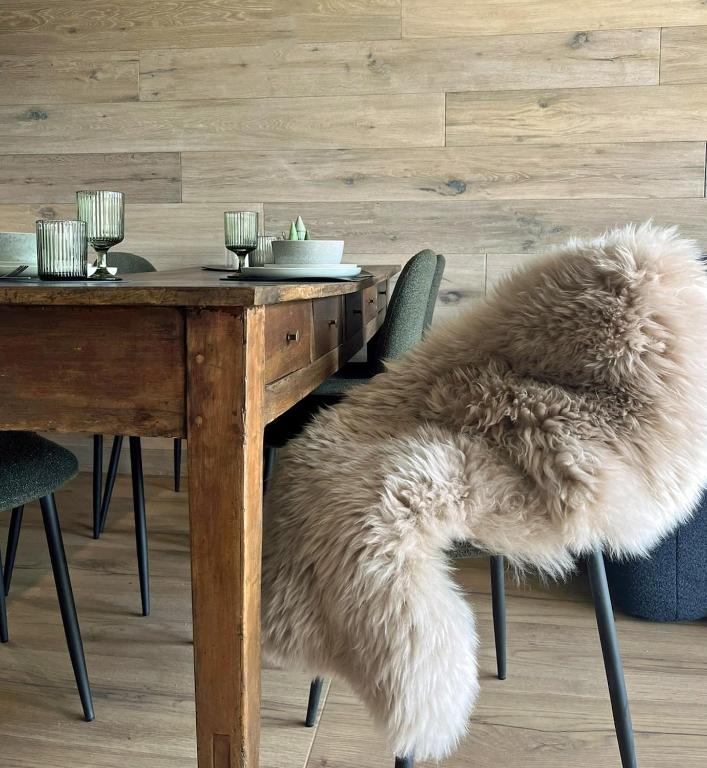 a dining room table with a faux fur rug on a table at Casa d'Alpe -Boutique apartment Chaberton view in San Sicario