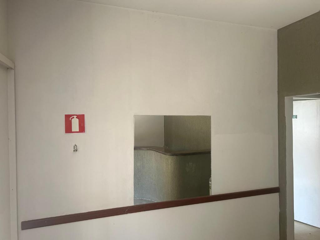 a mirror on a white wall in a room at Suíte 06 no centro da cidade in Uberaba