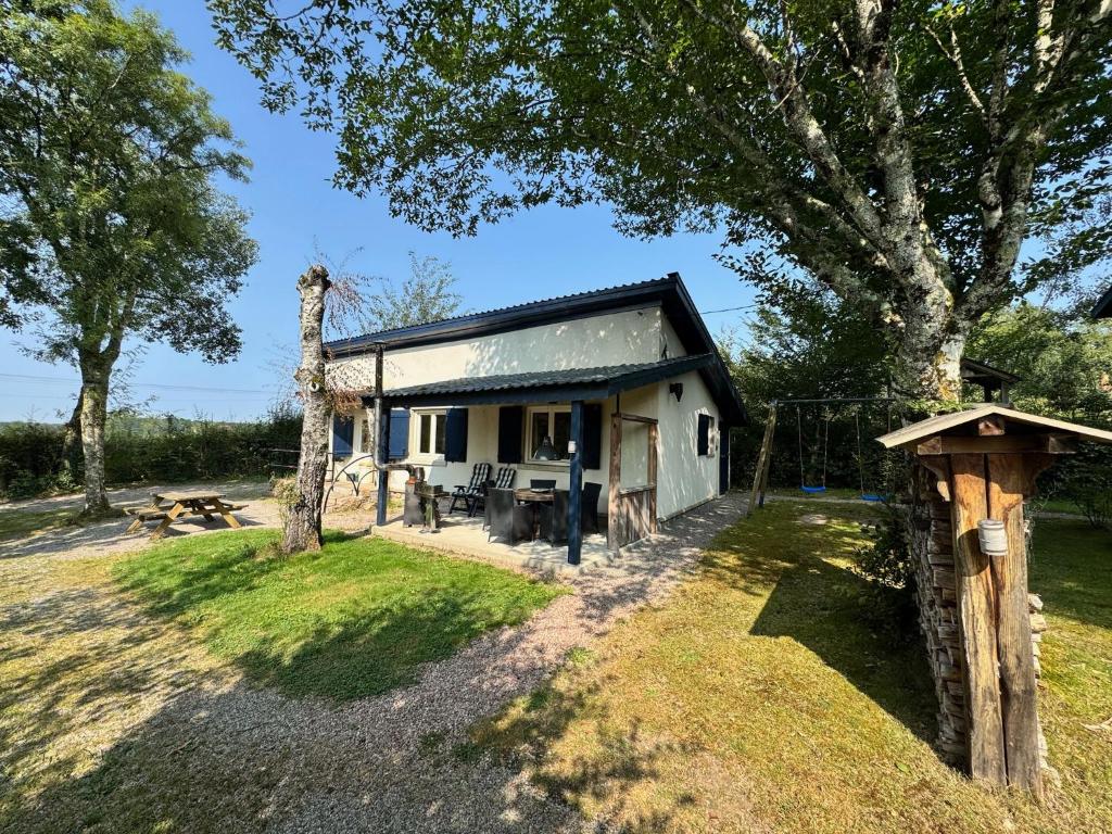ein kleines weißes Haus mit einem Baum in der Unterkunft Maison Annelore in Saint-Honoré-les-Bains
