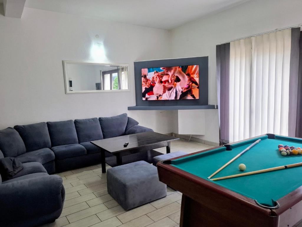 a living room with a couch and a pool table at Apartments Žera in Vlasic