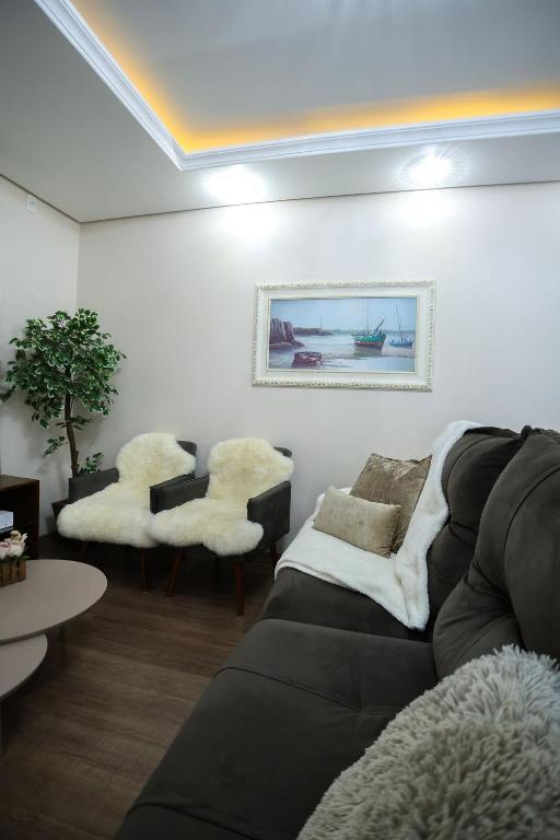 a living room with a couch and two chairs at Casa Petri Gramado casa inteira para 7 pessoas ideal para famílias in Gramado