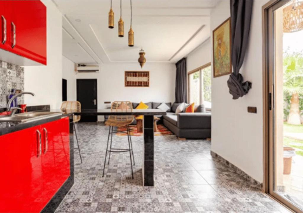 eine Küche und ein Wohnzimmer mit einem Tisch und einer Couch in der Unterkunft Villa Marrakech réservée aux familles in Marrakesch