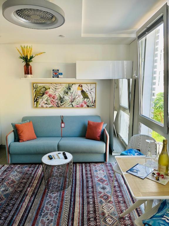 a living room with a blue couch and a table at AMBER APARTMENTS - FRESH STUDIO in Morro del Jable