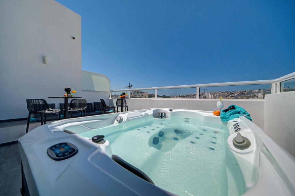 a jacuzzi tub on the roof of a house at Tritoni Alta suites in Il-Gżira