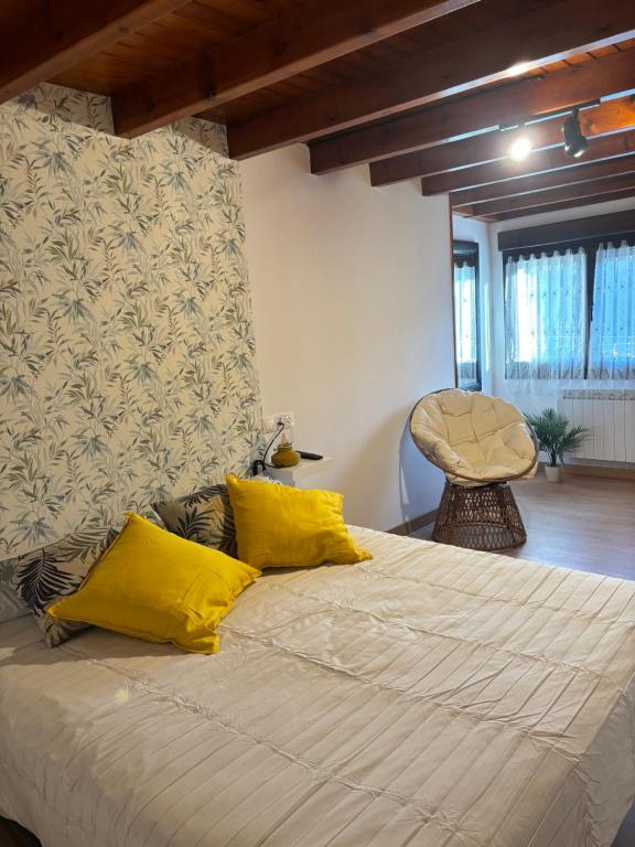 a bedroom with a large bed with yellow pillows at Casa Criseva II in Avín