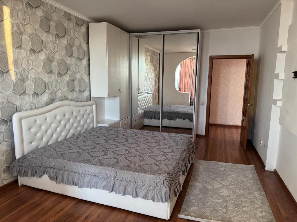 a bedroom with a bed and a large mirror at Актобе ажары in Aktobe