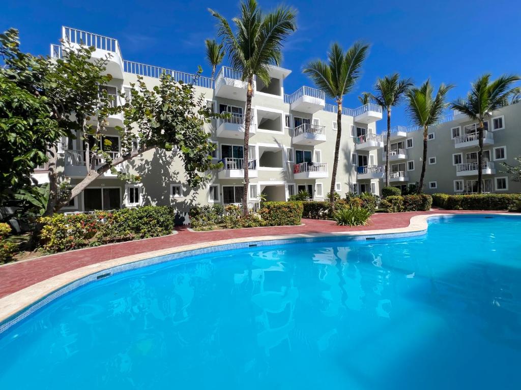 una gran piscina frente a un edificio en Nice condo with fresh pool, en Punta Cana