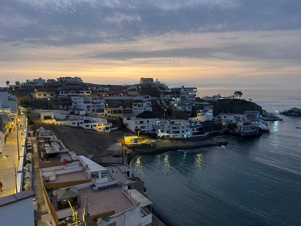 a group of white buildings in a town next to the water at Departamento en malecon acogedor in San Bartolo