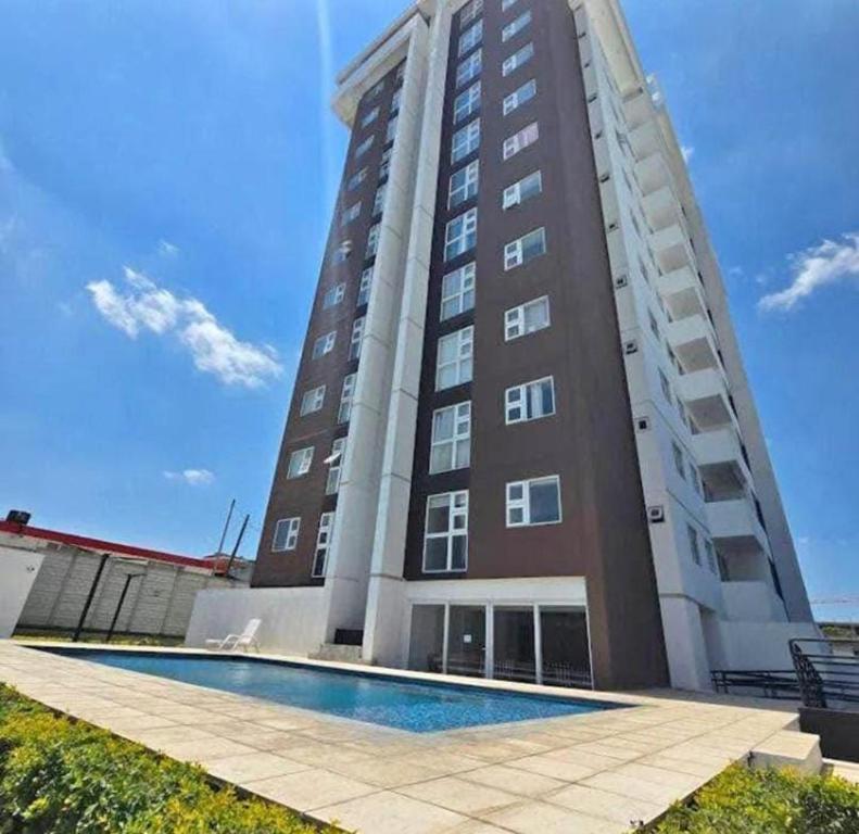 een hoog gebouw met een zwembad ervoor bij Casa Milos in Guatemala