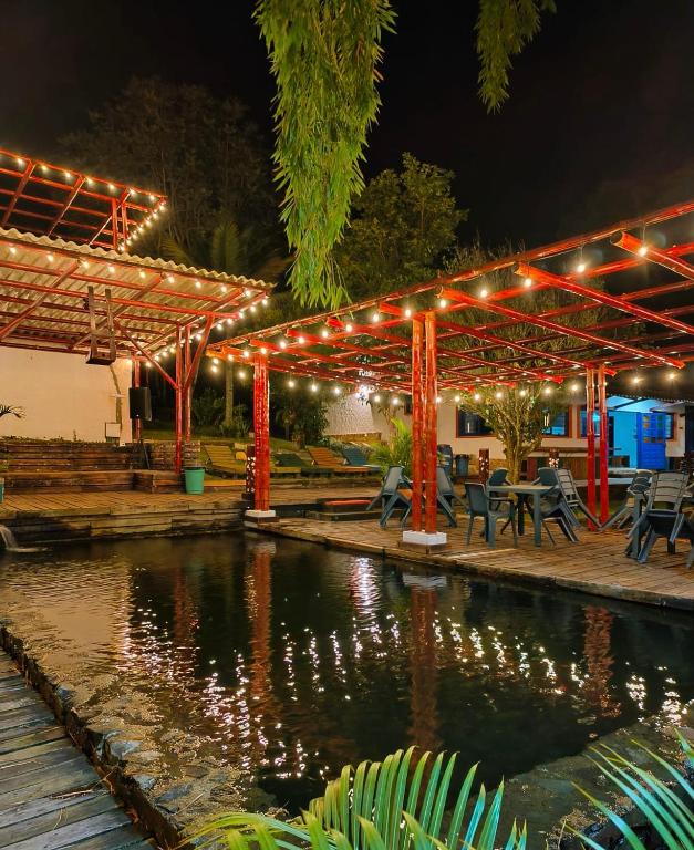 a pavilion with lights over a pond at night at Finca privada de lujo Casalegre in Pance
