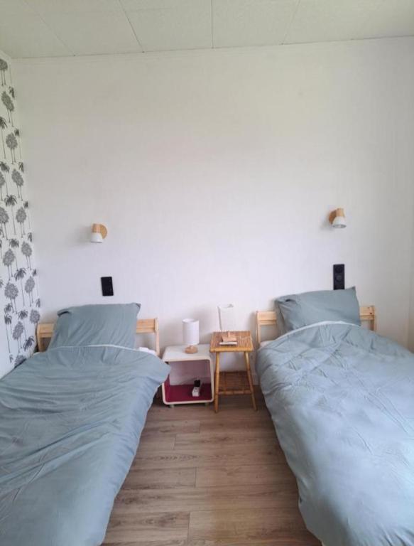 two beds sitting next to each other in a bedroom at Colocation in Trignac