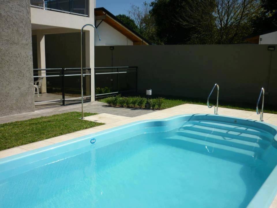 Una gran piscina azul frente a una casa en Cuatro Estaciones, en San José