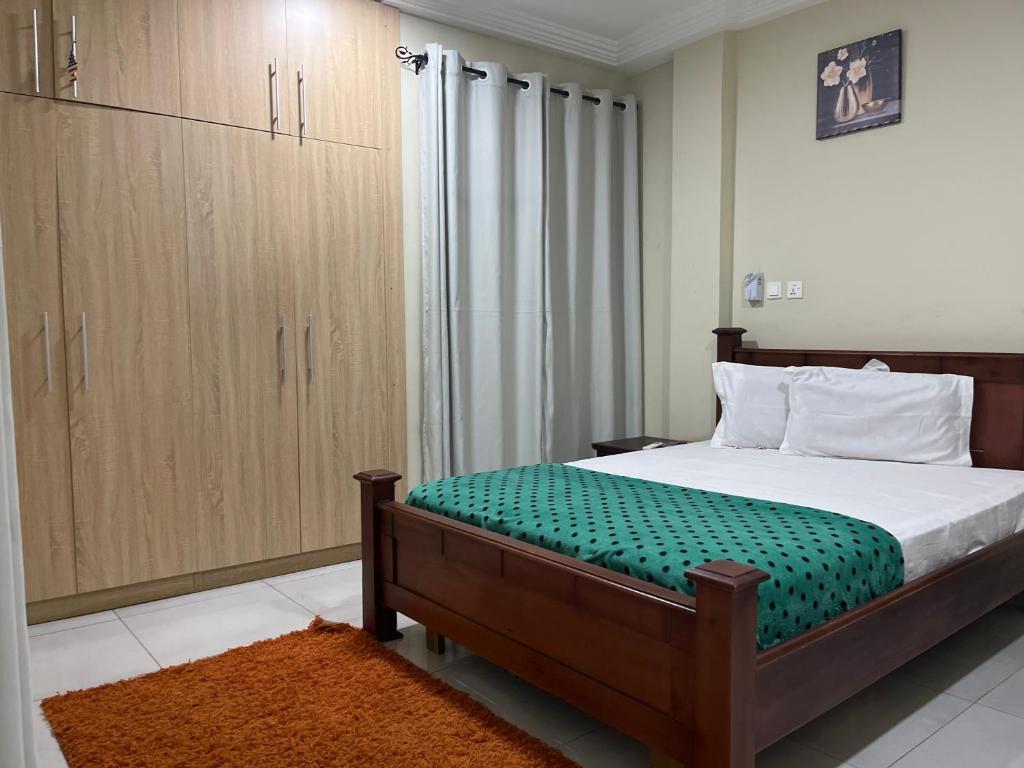 a bedroom with a bed and a large closet at Beatrice court in Accra