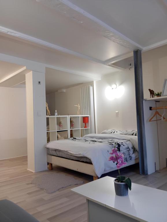 a white bedroom with a bed and a desk at Studio Chavigny avec wifi in Chavigny