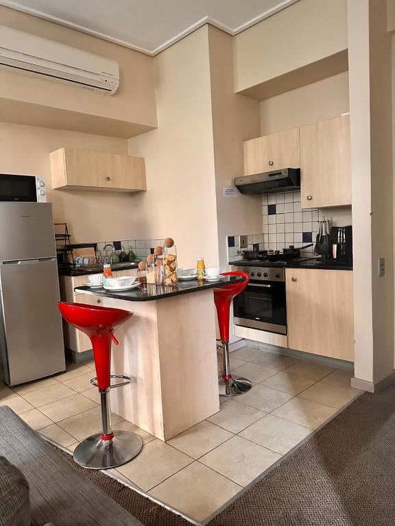 a kitchen with red stools and a counter in a room at Swanky Spectacular Hotel in Johannesburg