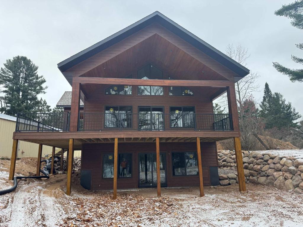 a large wooden house with a large balcony at 5 Bdrm 12 Guest LakeHouse with Private Boat Dock in Round Lake Seaplane Base