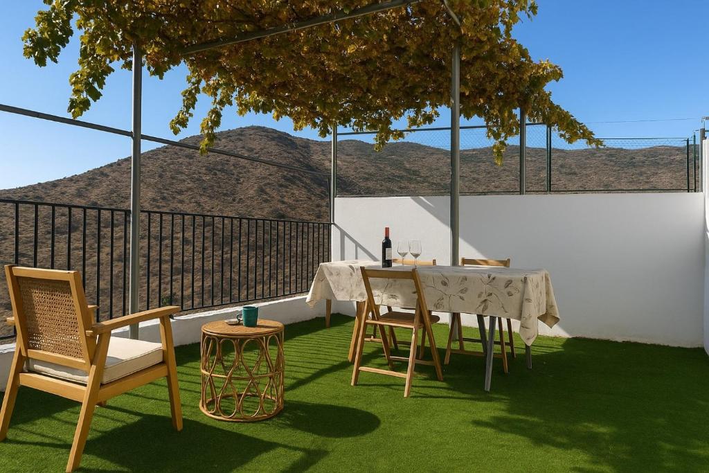 a table and chairs on a balcony with a view of a mountain at Casa del Agua - Escapada rural con chimenea y vistas a Sierra Nevada in Abrucena
