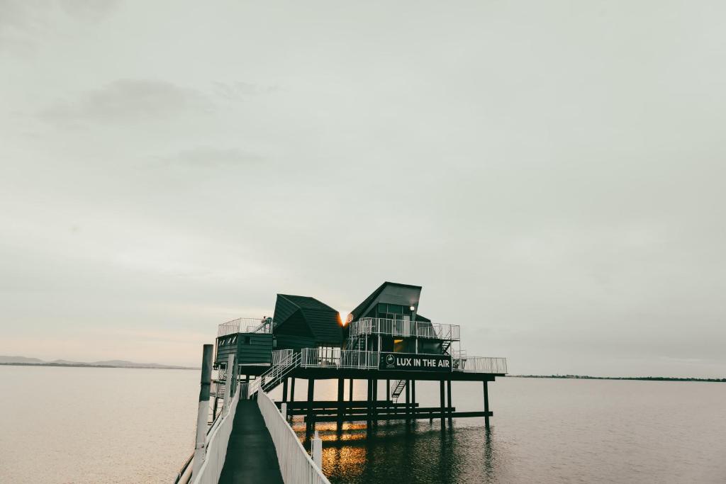 a dock in the water with a building on it at LUX IN THE AIR - An Elevated Experience on the Vaal Dam in Denysville