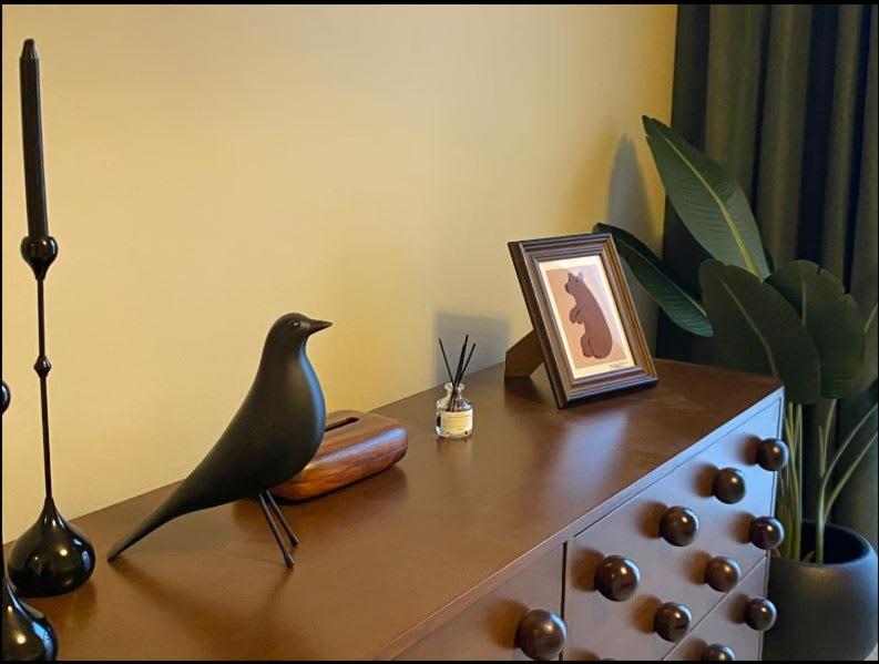 Una figura de un pájaro sentado en una cómoda. en The Poet Den with 120 inch screen, en Yas Island