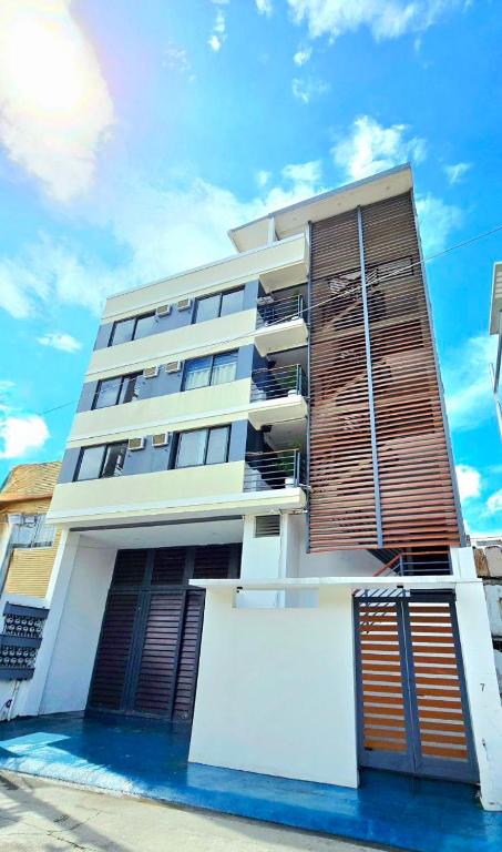 a large white building with wooden shutters on it at Studio Units near Airport by Jade Studio Apartments in Manila