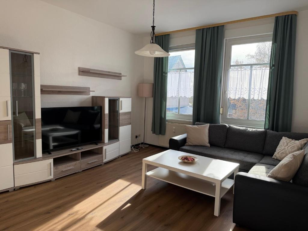 een woonkamer met een bank en een tv bij Ferienwohnungen in Röblingen 