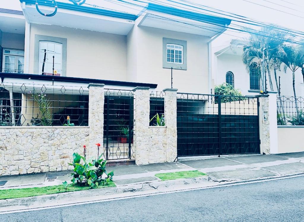 a house with a black gate in front of it at Ester`s Place in Escazu