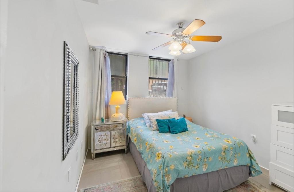 a bedroom with a bed and a ceiling fan at designer abode condo min to Manhattan in jersey city in Jersey City