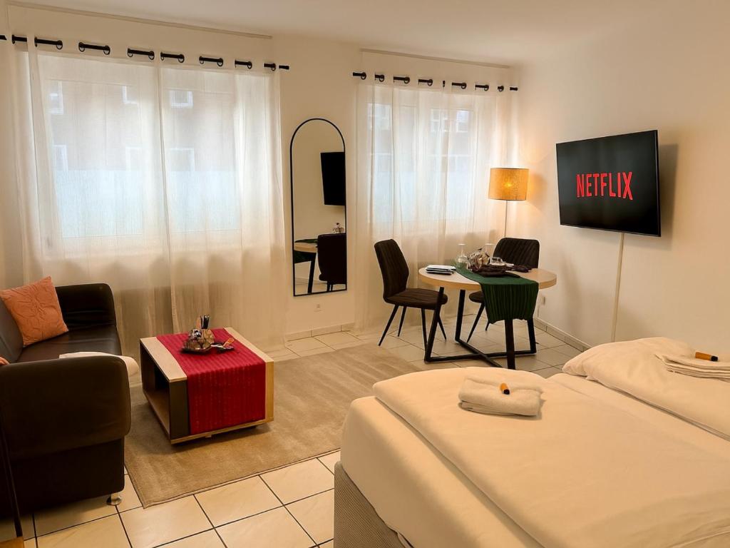 a hotel room with two beds and a table at Modernes Studio im Herzen von Würselen, gemütlich, zentral & mit Netflix in Würselen