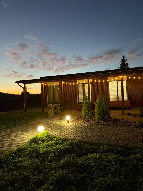 ein Haus mit Lichtern davor in der Nacht in der Unterkunft Porichka Home in Roslavichi