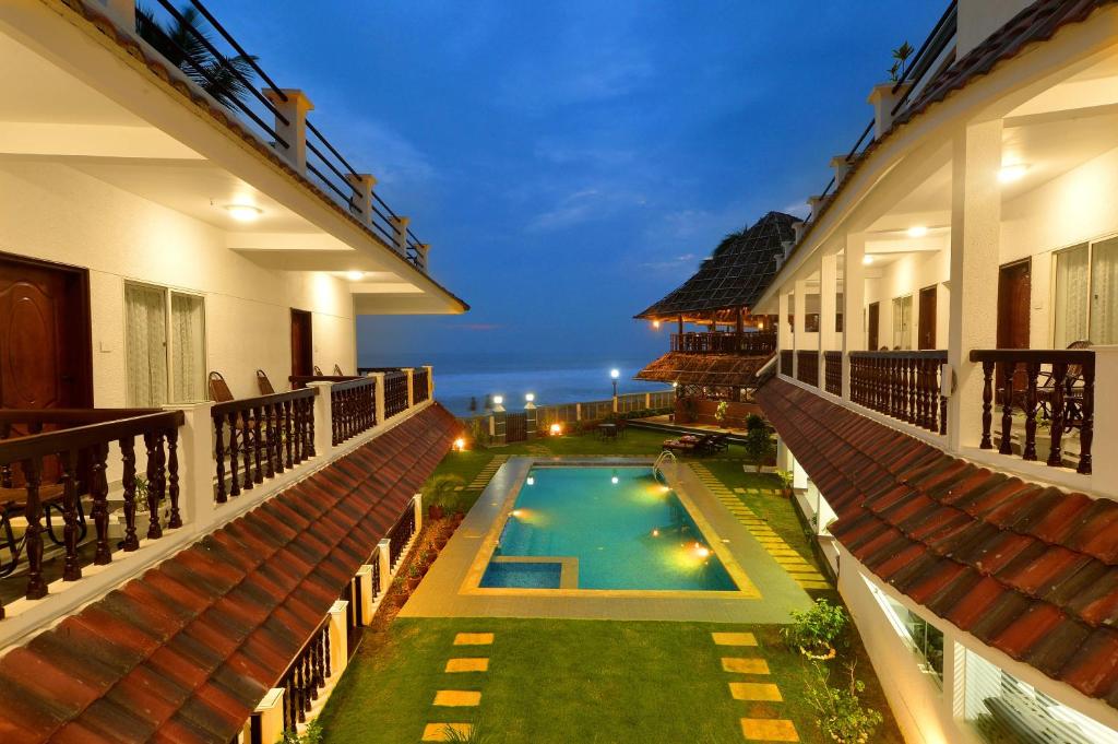 a swimming pool in the middle of a building at B'Canti Boutique Beach Resort in Varkala