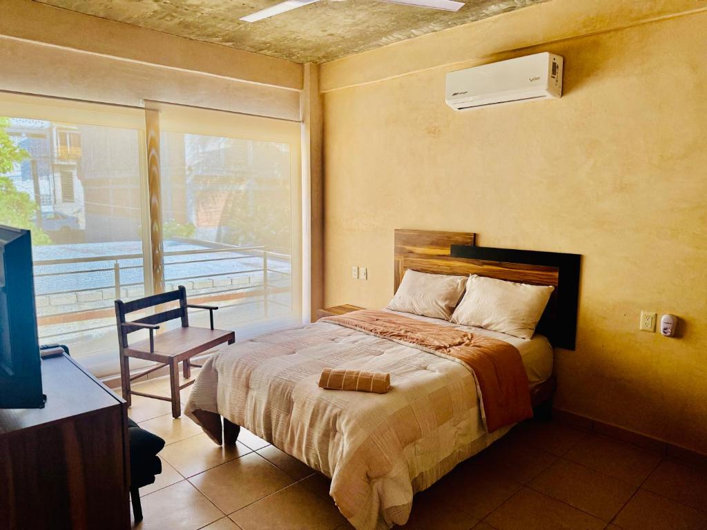 プエルト・エスコンディードにあるCasa Tachuのベッドとバルコニーのある寝室