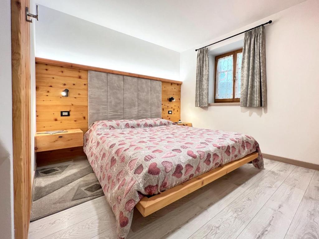 a bedroom with a bed and a window at tabià piz meda in Moena